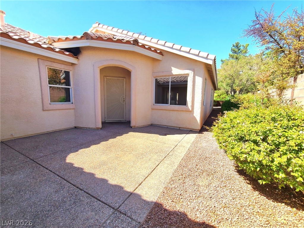2278 Chestnut Ranch Avenue Henderson, NV 89052 - Photo 2 of 18 A terracotta-tiled roof crowns this appealing stucco residence, framed by mature trees and verdant shrubs.