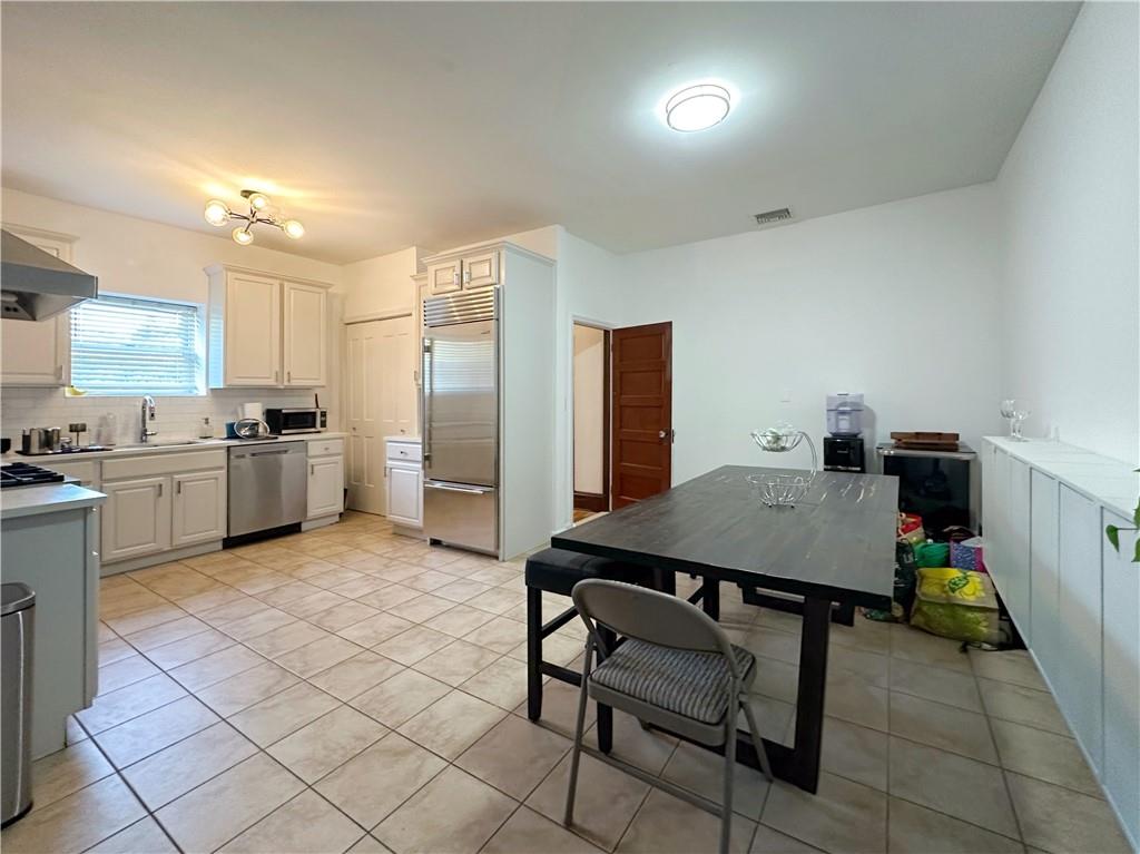 655 76th Street Brooklyn, NY 11209 - Photo 21 of 30 a kitchen with a table chairs refrigerator and microwave