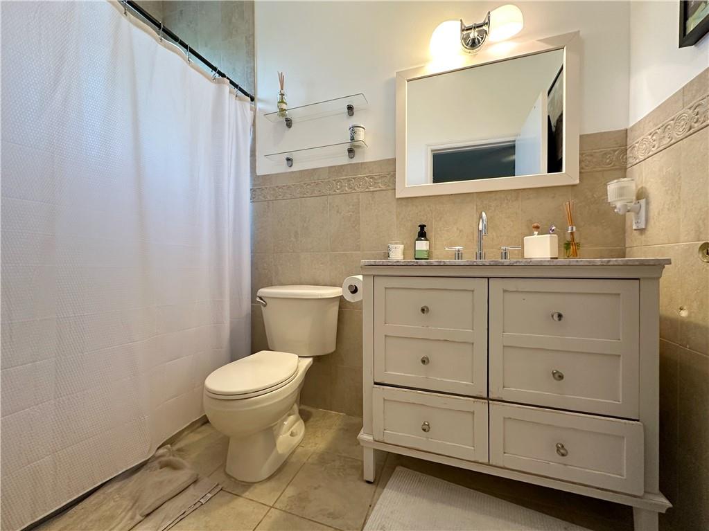 655 76th Street Brooklyn, NY 11209 - Photo 24 of 30 a bathroom with a granite countertop toilet sink and mirror