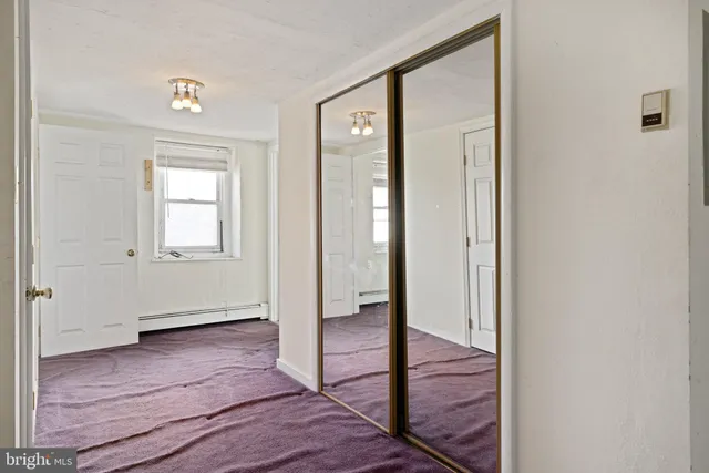 a view of a hallway with wooden floor and closet