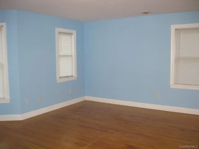 an empty room with wooden floor and a window