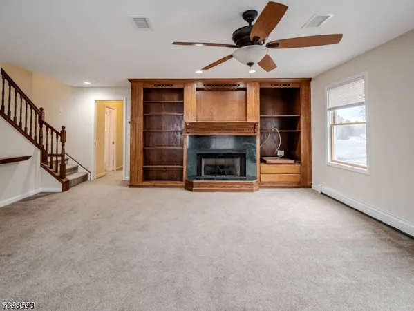 wooden floor in an empty room with a fireplace and a window
