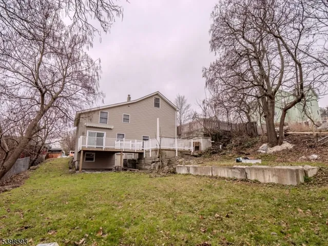 a view of a house with a yard covered with snow and trees