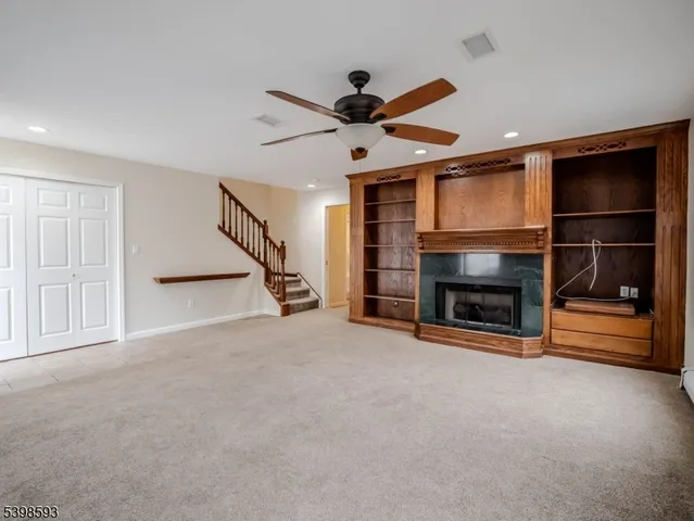 a view of an empty room with fireplace garage and windows