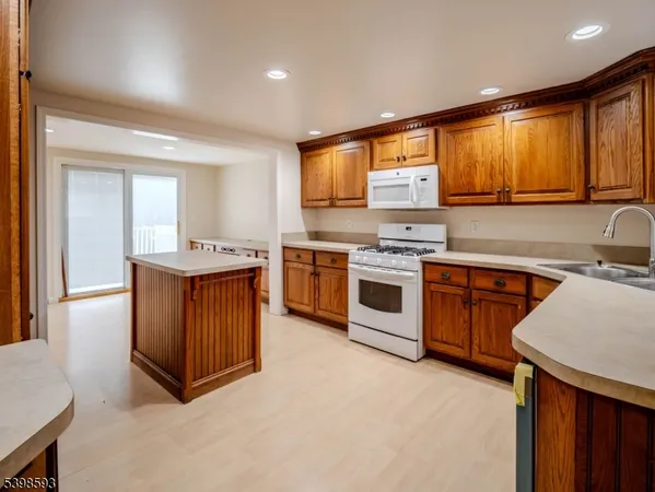 a kitchen with stainless steel appliances granite countertop wooden cabinets a sink and a stove