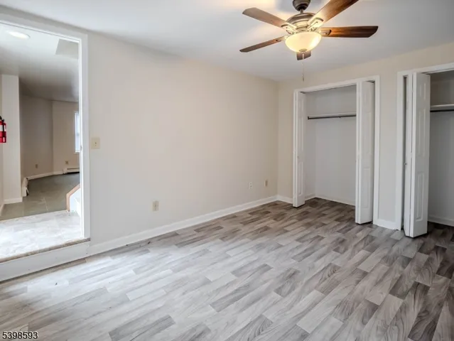 a view of a livingroom with wooden floor and a ceiling fan
