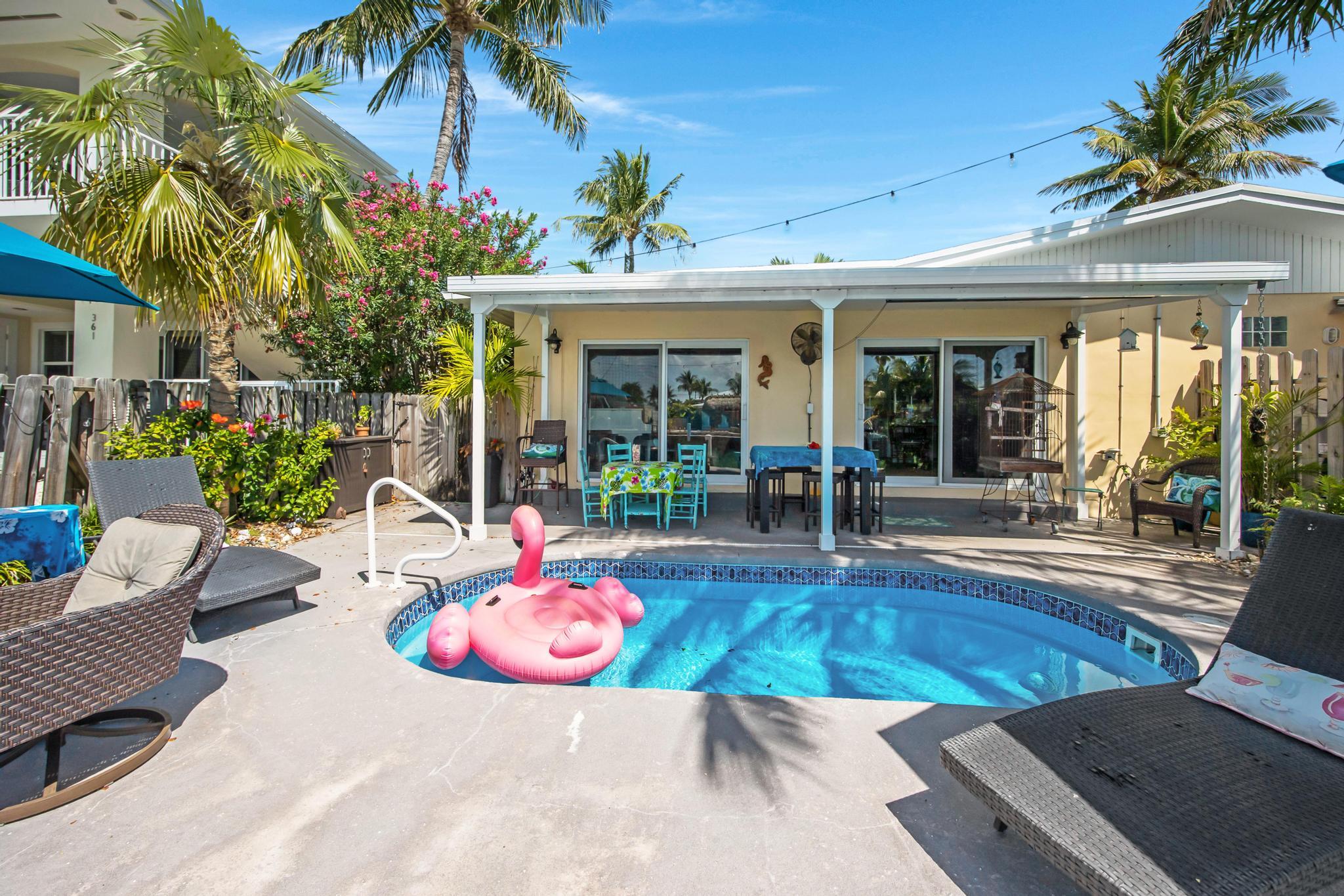 351 8th Street Key Colony Beach, FL 33051 - Photo 32 of 38 a view of a patio with table and chairs potted plants and floor to ceiling window and potted plants