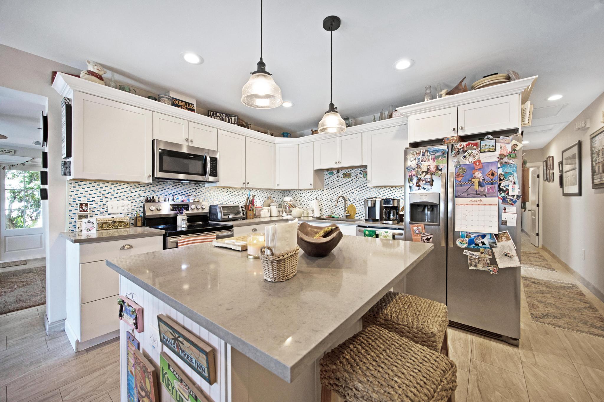 351 8th Street Key Colony Beach, FL 33051 - Photo 8 of 38 a kitchen with stainless steel appliances granite countertop a sink a stove and a refrigerator