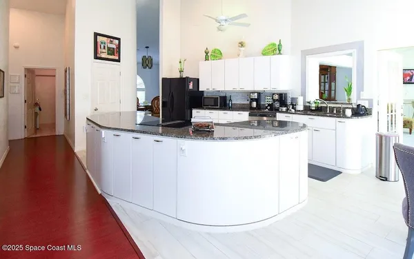 a kitchen with kitchen island granite countertop a sink a stove and a wooden floors