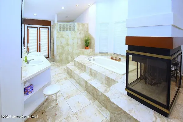 a bathroom with a tub sink and mirror