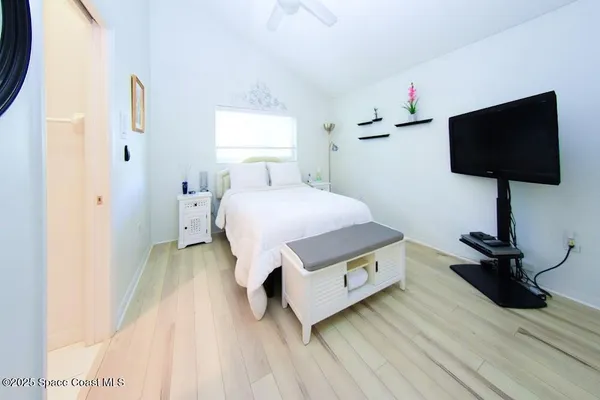 a bedroom with a bed tv and a window