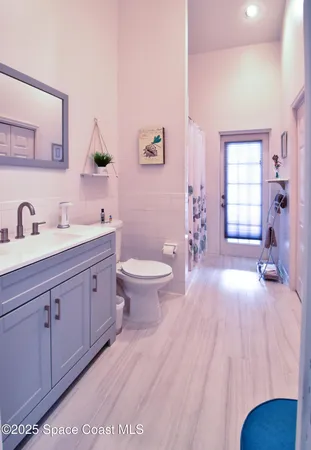 a spacious bathroom with a double vanity sink a toilet and a mirror