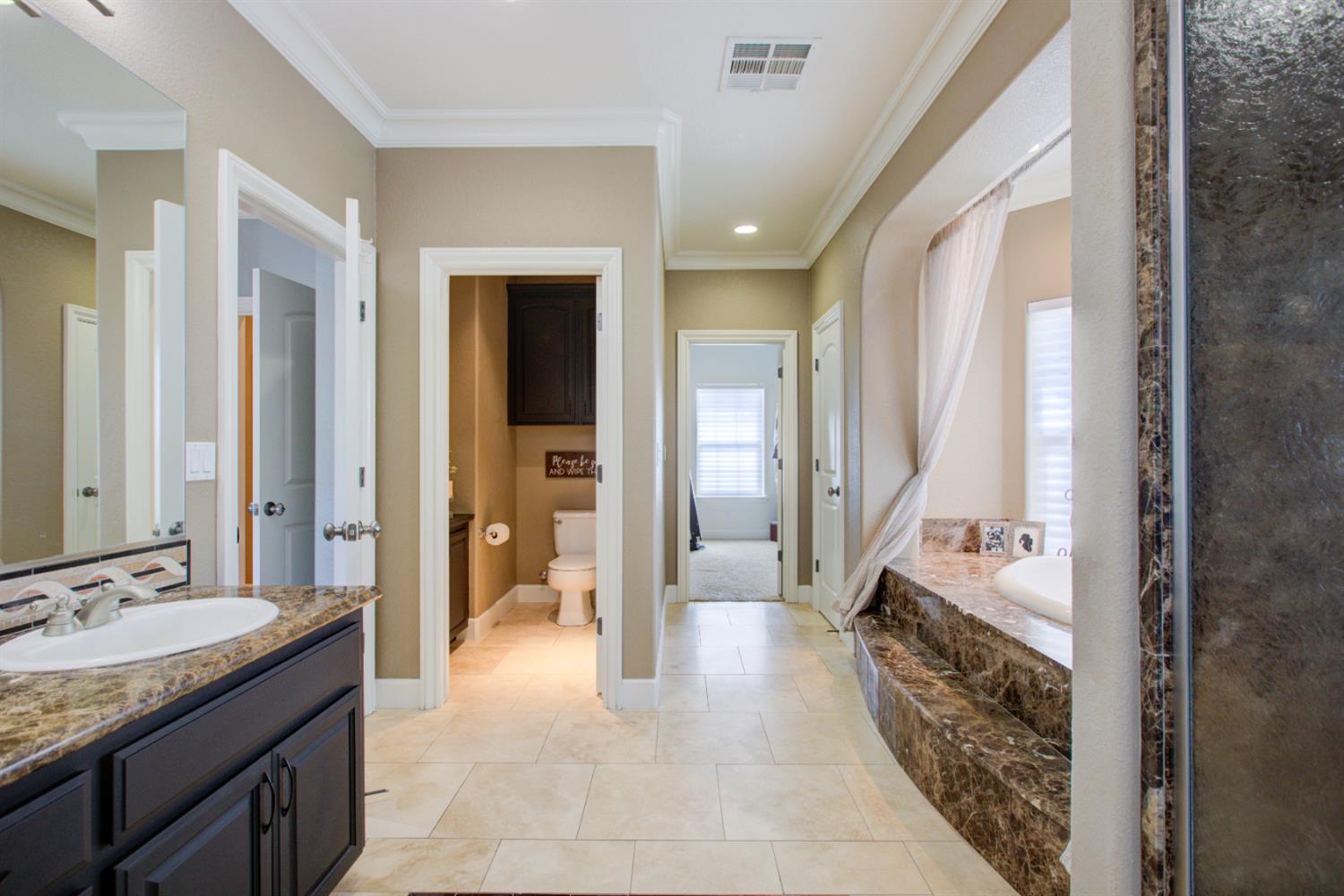 1054 Townhill Road Oakdale, CA 95361 - Photo 35 of 60 a bathroom with a granite countertop sink a mirror and a vanity