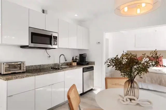 a kitchen with stainless steel appliances granite countertop a sink a stove a microwave a counter space and cabinets