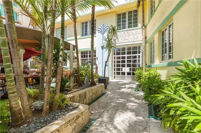 a view of a house with a large windows and flower plants