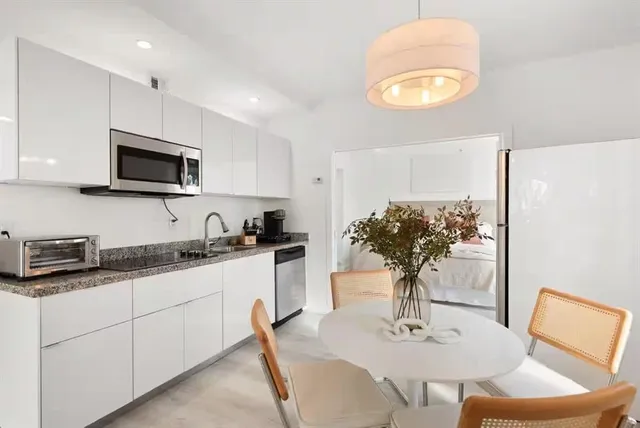 a kitchen with stainless steel appliances granite countertop a sink a stove a microwave a refrigerator and cabinets