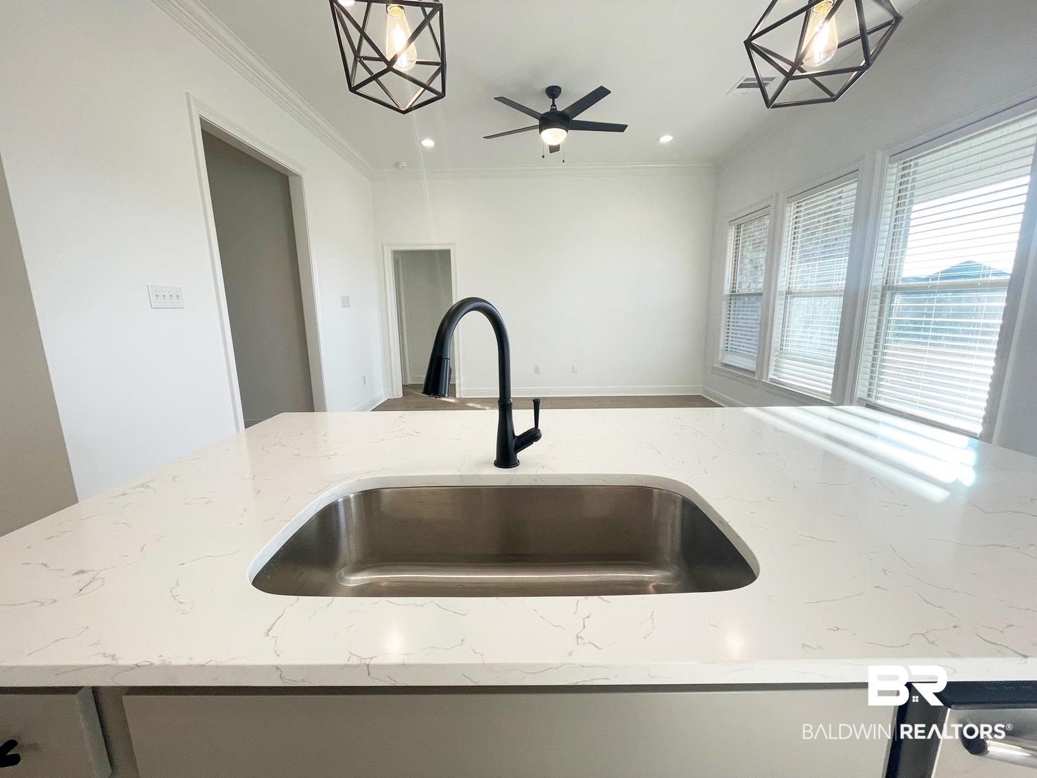 1403 Fenton Circle Foley, AL 36535 - Photo 4 of 15 Kitchen with light stone counters, crown molding, decorative light fixtures, and sink