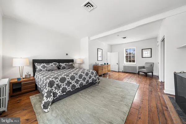 a bedroom with a large bed and a wooden floor