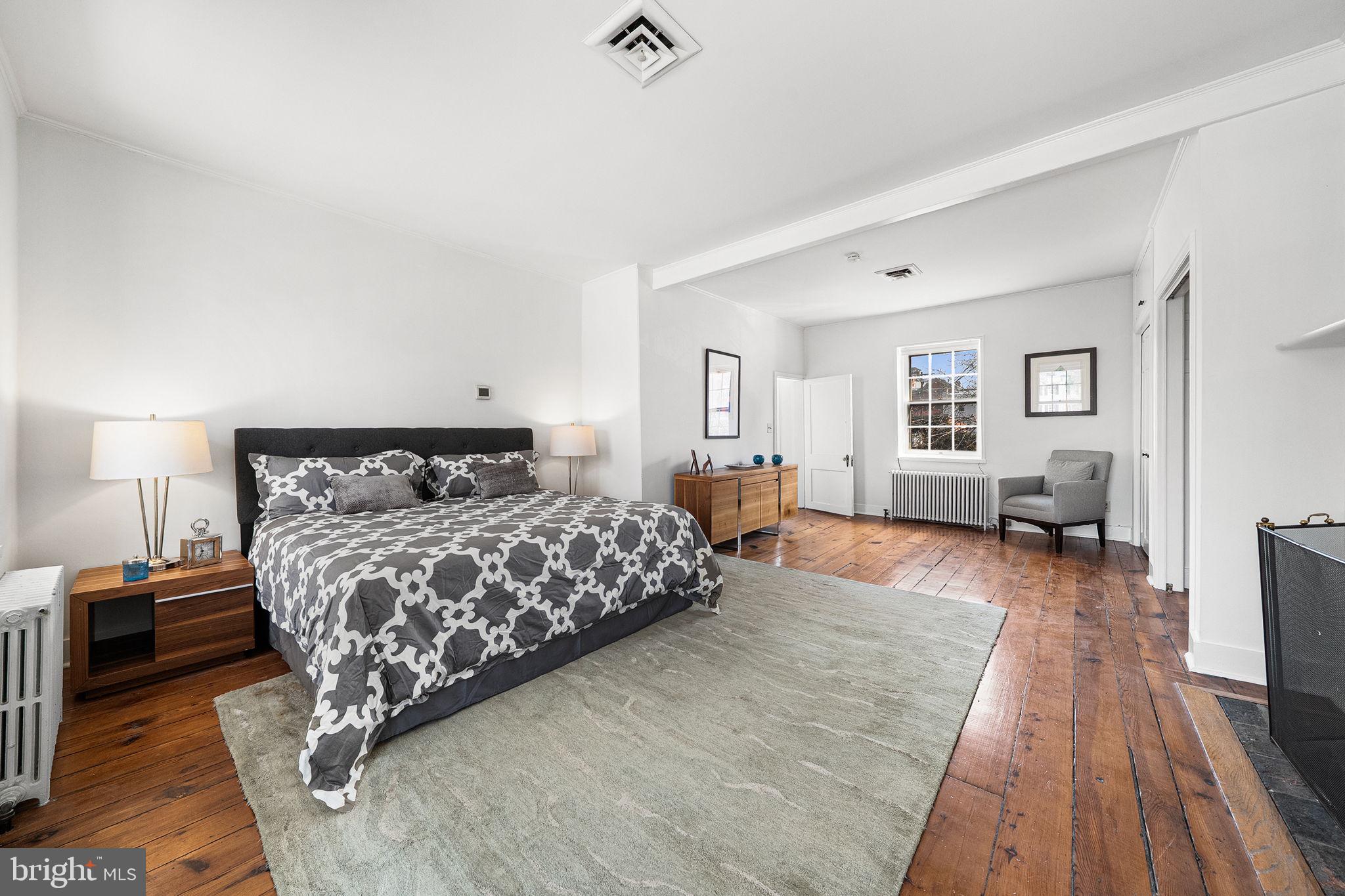 106 North Court Street Frederick, MD 21701 - Photo 16 of 34 a bedroom with a large bed and a wooden floor