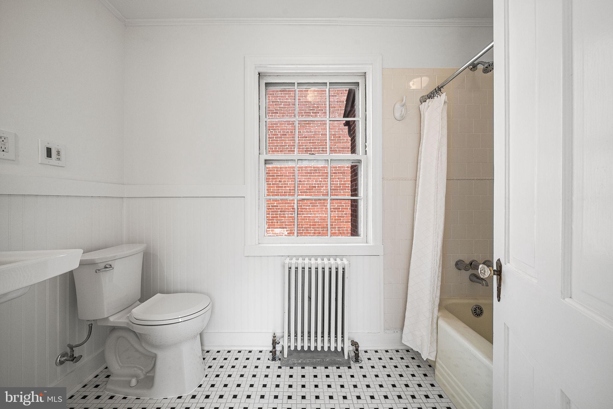 106 North Court Street Frederick, MD 21701 - Photo 22 of 34 a bathroom with a toilet a window and a shower