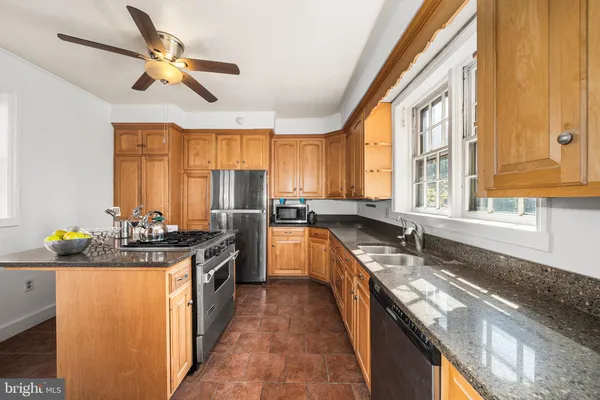 a kitchen with stainless steel appliances granite countertop a sink a stove and a refrigerator