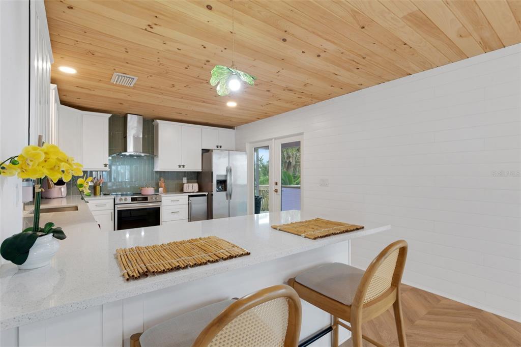 8390 Little Gasparilla Placida, FL 33946 - Photo 8 of 81 a kitchen with stainless steel appliances granite countertop a kitchen island a stove a sink a dining table and chairs with wooden floor