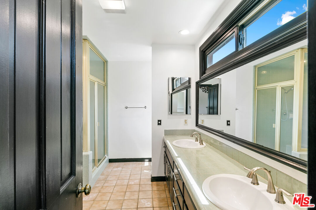 29528 Harvester Road Malibu, CA 90265 - Photo 29 of 41 a bathroom with a granite countertop sink and a mirror