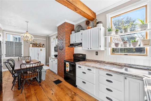 a kitchen with granite countertop a sink appliances cabinets and furniture