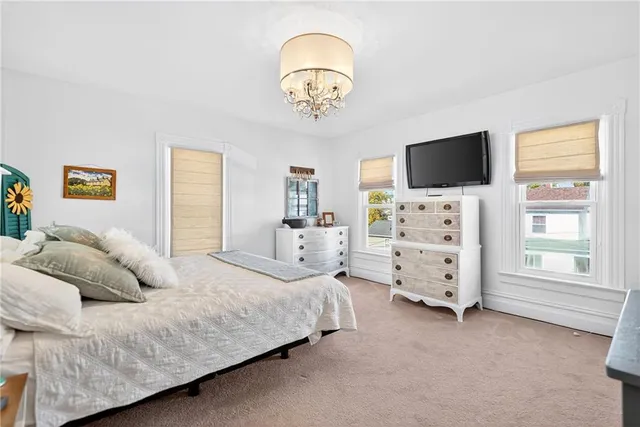 a bedroom with a bed and a flat tv screen on dresser