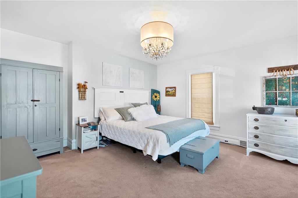 722 8th Street Irwin, PA 15642 - Photo 31 of 50 a spacious bedroom with a bed and a chandelier