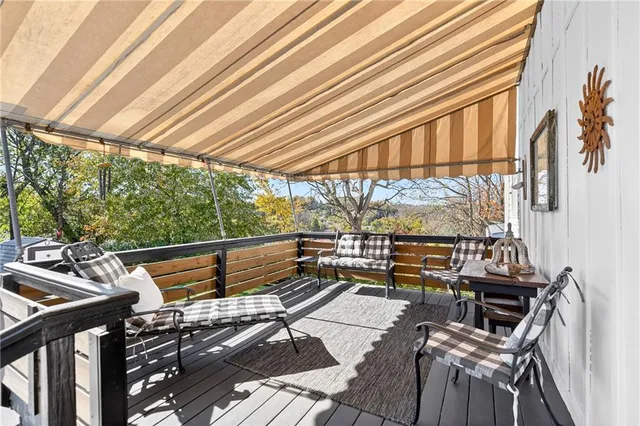 a view of a balcony with chairs and wooden floor