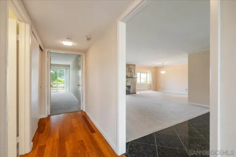 a view of hallway with bathroom and wooden floor