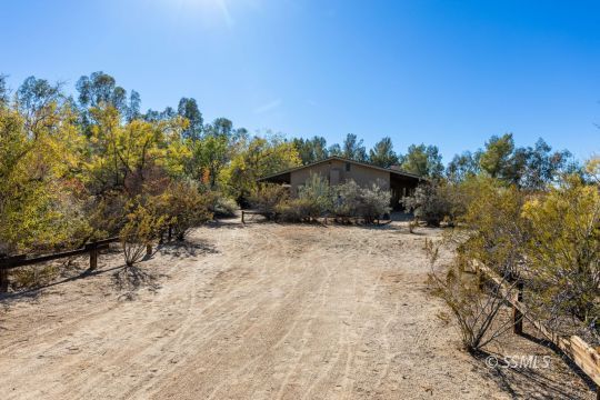 1029 Leslie Street Ridgecrest, CA 93555 - Photo 8 of 40 a view of a dry yard with trees