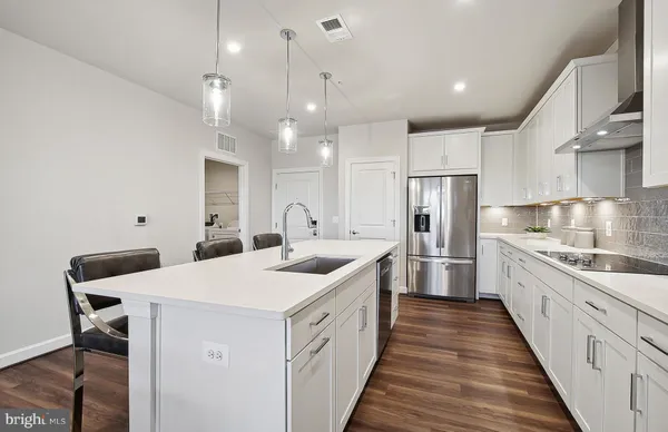 a kitchen with a table chairs refrigerator and cabinets