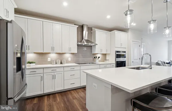 a large kitchen with stainless steel appliances kitchen island a large counter tops a stove a sink and a refrigerator