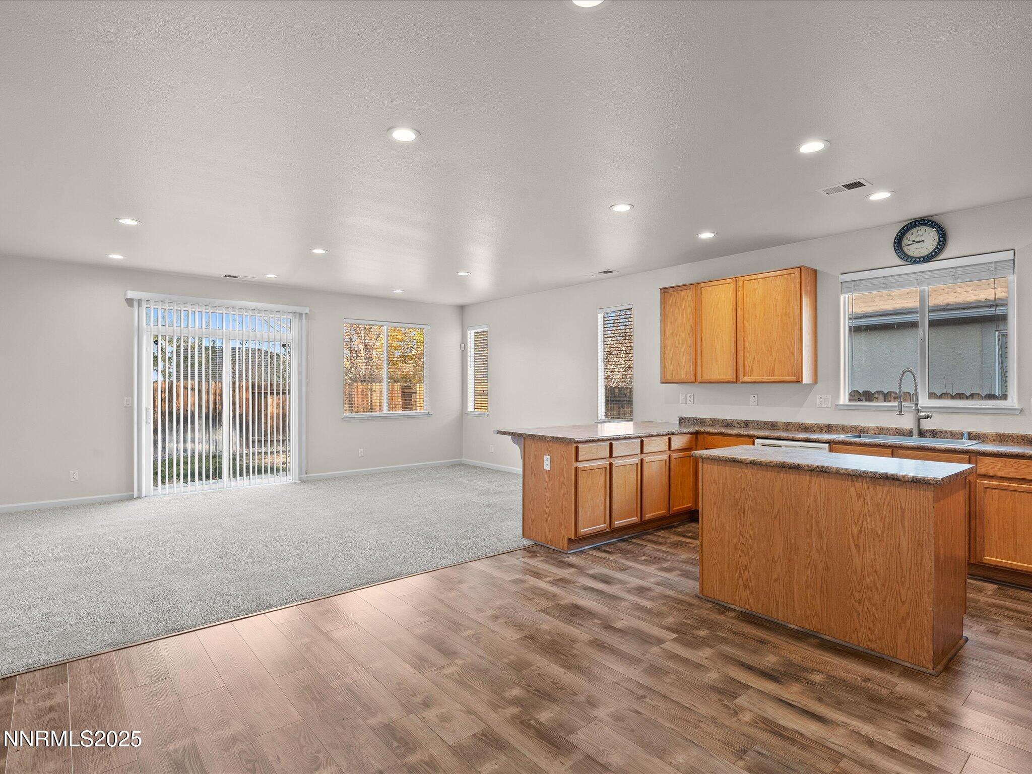 10873 Rushing Flume Drive Reno, NV 89521 - Photo 6 of 37 a large kitchen with kitchen island a sink wooden floor and glass doors