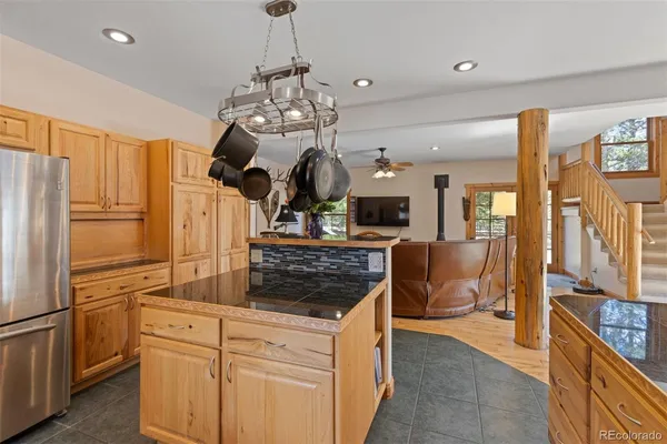 a kitchen with stainless steel appliances granite countertop a sink a stove and a refrigerator