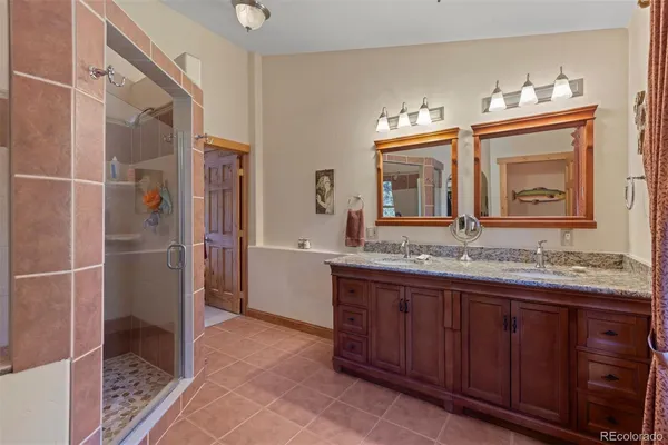 a bathroom with a granite countertop sink a mirror and a shower