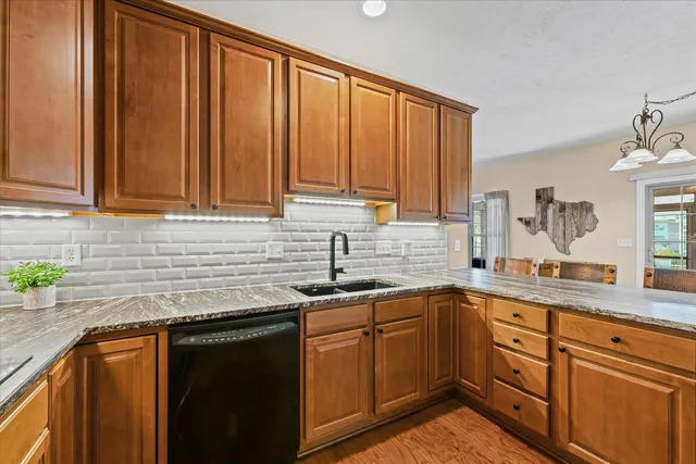 a kitchen with stainless steel appliances granite countertop a sink a stove a counter space and cabinets