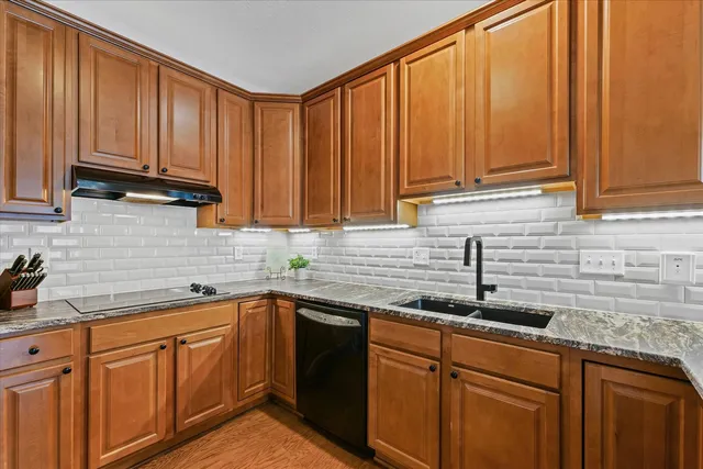 a kitchen with stainless steel appliances granite countertop a sink a refrigerator and cabinets
