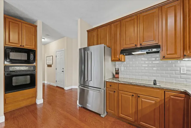 a kitchen with granite countertop stainless steel appliances a stove and a sink
