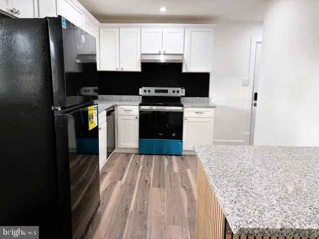 a kitchen with a stove a refrigerator and a sink