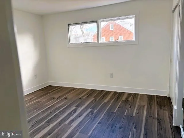 an empty room with windows and fireplace