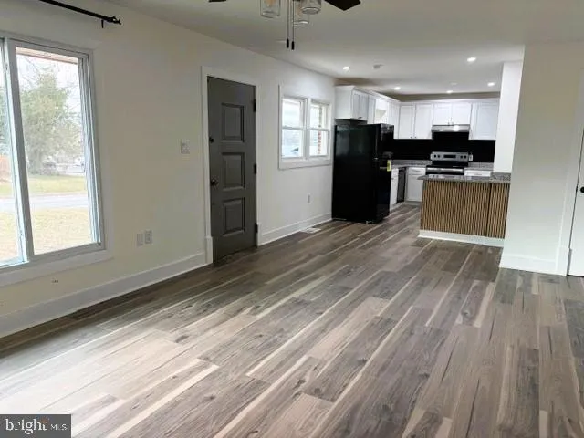a kitchen with granite countertop white cabinets and black appliances