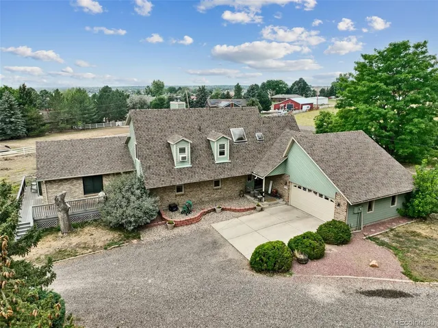 an aerial view of a house with a garden and outdoor seating