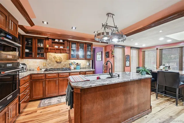 a kitchen with stainless steel appliances granite countertop a sink stove and refrigerator