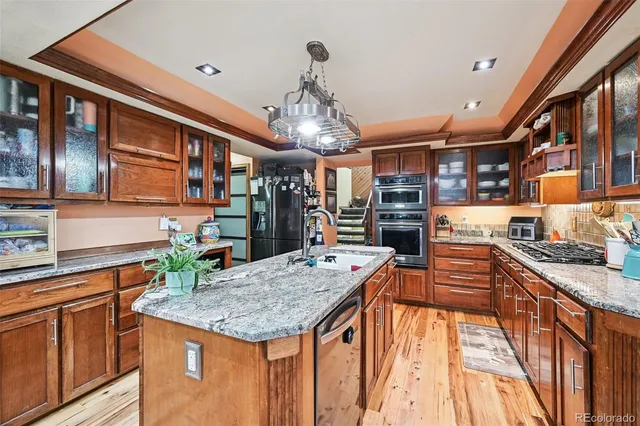 a kitchen with stainless steel appliances granite countertop a kitchen island a stove and a sink