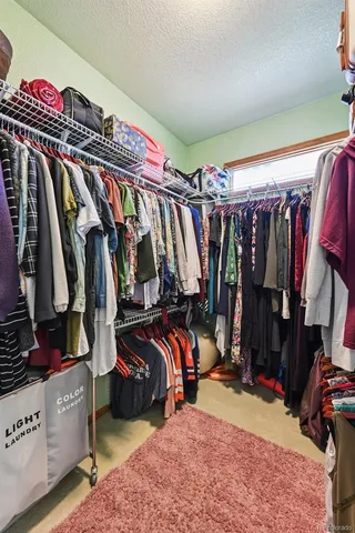 a view of walk in closet with clothes and shoes