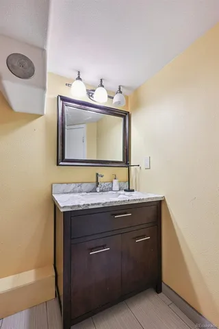 a bathroom with a granite countertop sink a large mirror and vanity