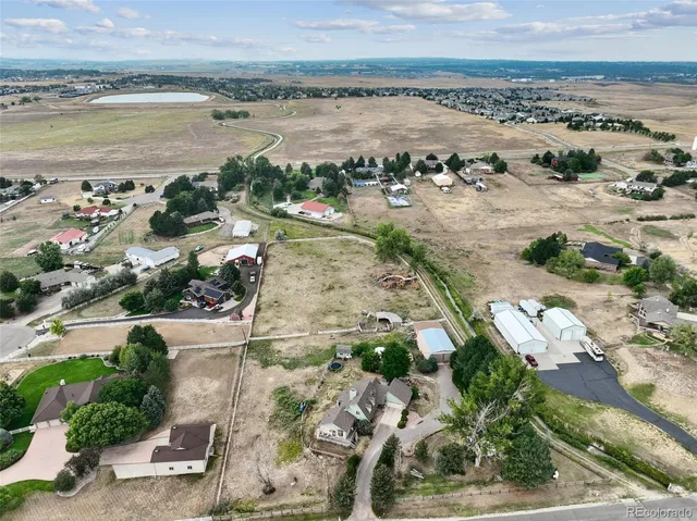 an aerial view of ocean and residential houses with outdoor space